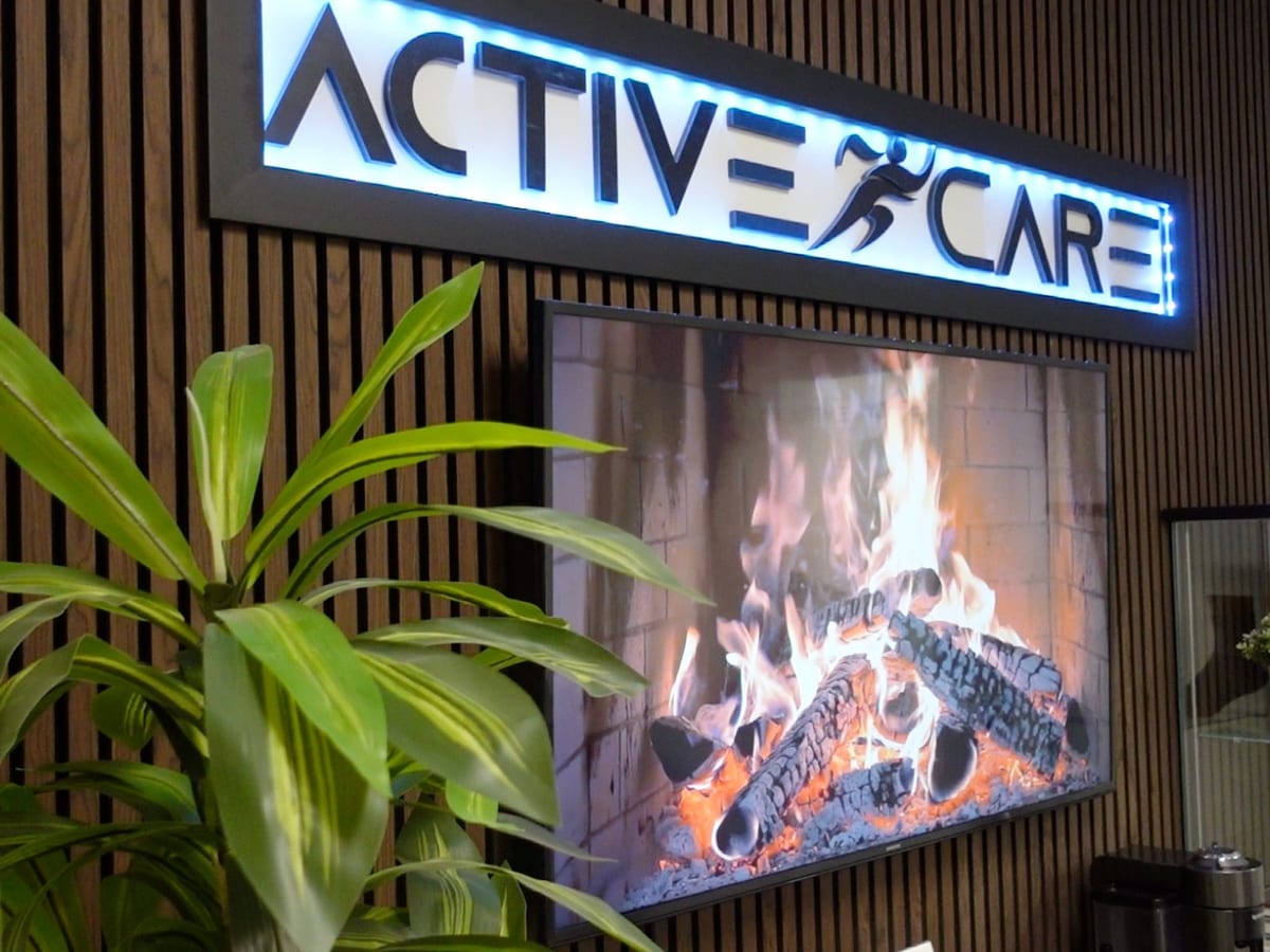 The Active Care Oakville lounge, with the clinic's sign lit above a fireplace