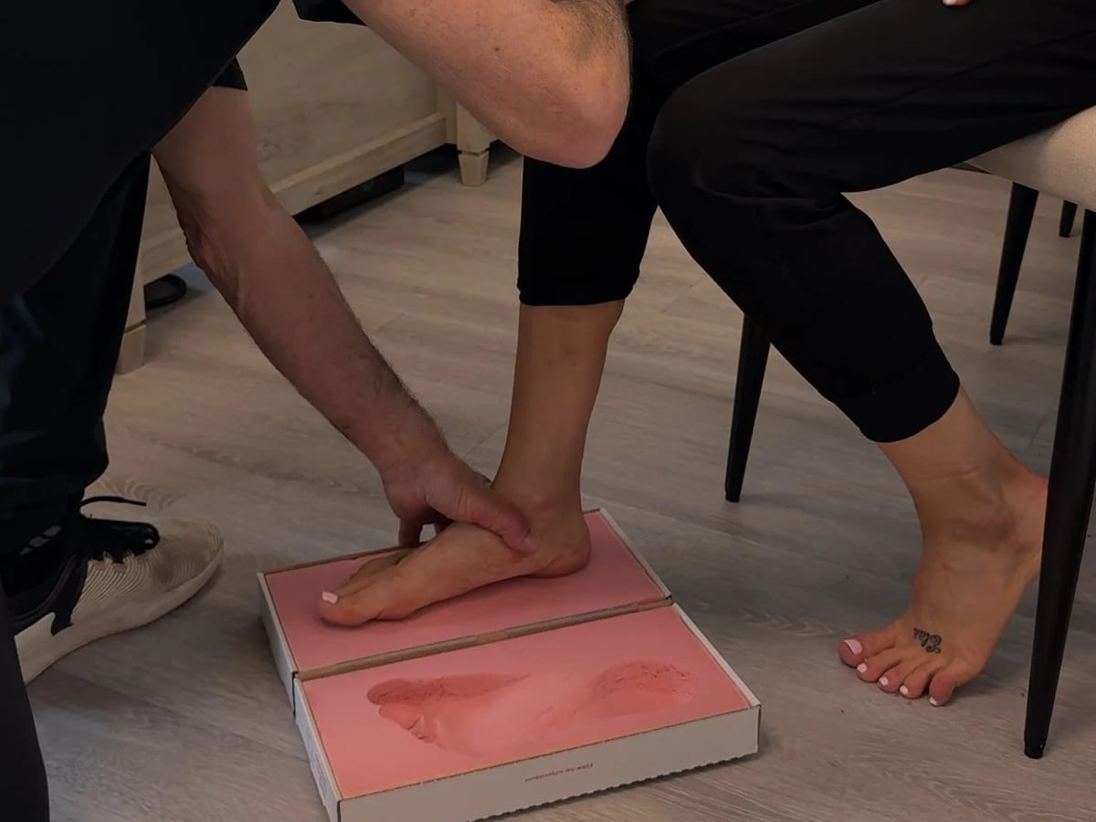 A chiropodist taking a foam impression of a patient's foot for custom orthotics
