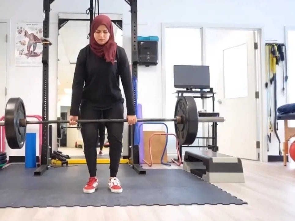 The rehabilitation gym at Active Care Oakville, with a squat rack, free weights and matted floor